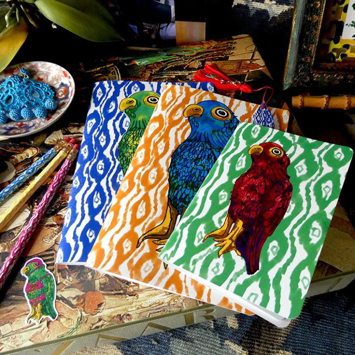 Parrot patterned notebooks in various colors with either ikay or cabana stripe backgrounds